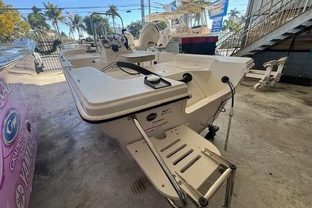 Slide: The Image of 2023 Carolina Skiff 162 JLS boat in showroom, featuring a sleek design and spacious deck. - 16