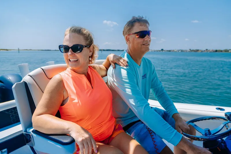 Slide: The Image of 2026 Tidewater 256 LXF boat cruising on a river under a blue sky. - 12