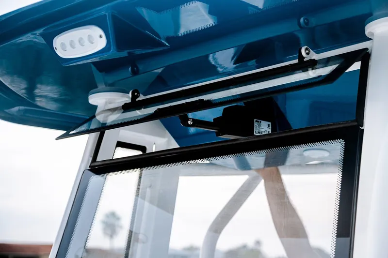 Slide: The Image of 2026 Tidewater 256 LXF boat in showroom, featuring dual outboard engines on trailer. - 29