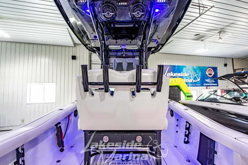Slide: The Image of 2026 Tidewater 256 LXF boat interior with rod holders and modern lighting in showroom. - 51