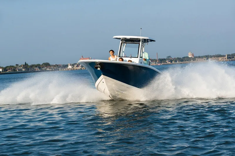 Slide: The Image of 2026 Tidewater 256 LXF boat cruising on a lake with dual engines. - 6