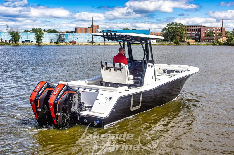 Slide: The Image of 2026 Tidewater 256 LXF boat on water, featuring dual outboard engines, under a blue sky. - 60