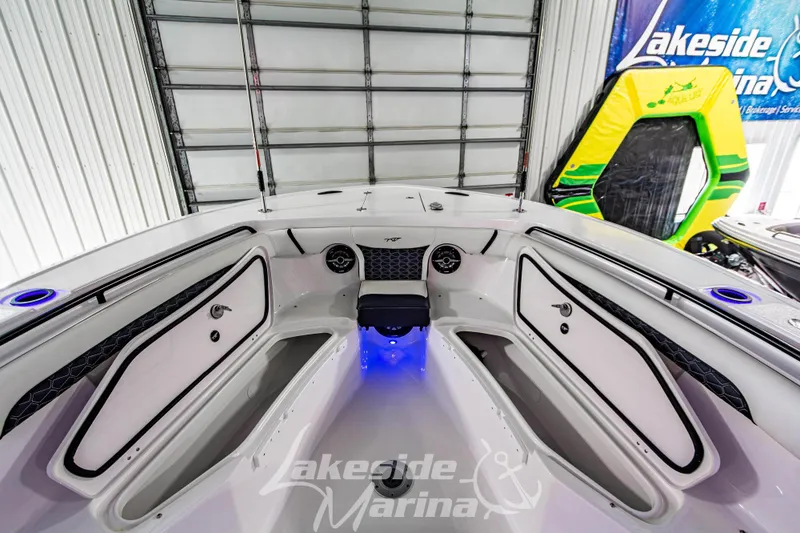 Slide: The Image of 2026 Tidewater 256 LXF boat interior with storage compartments and blue LED lighting. - 91