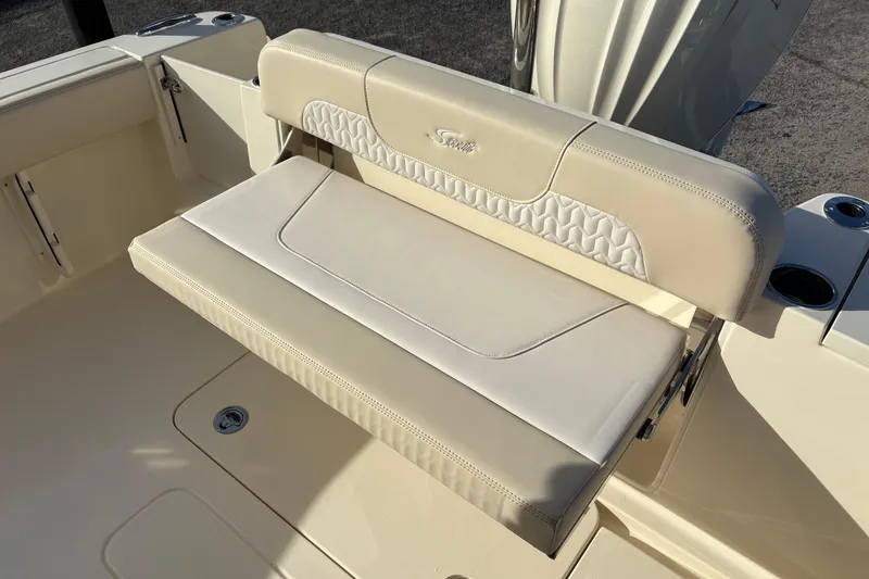 Slide: The Image of Open storage compartment on 2026 Scout 240 XSF boat, featuring cup holders and handle. - 11