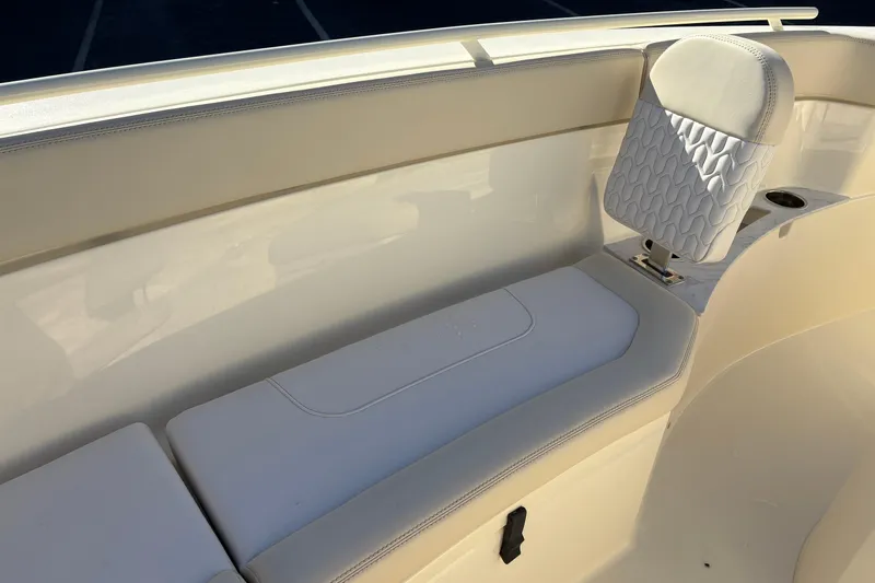 Slide: The Image of 2026 Scout 240 XSF boat interior with cushioned seating and cup holder. - 31