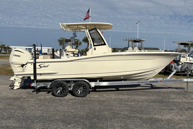 Slide: The Image of 2026 Scout 240 XSF boat on trailer, parked outdoors under clear sky. - 5