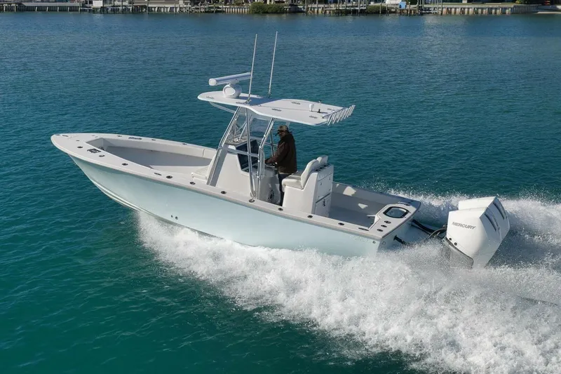 Slide: The Image of 2025 Conch 27 boat cruising on clear blue water with Mercury outboard engine. - 12