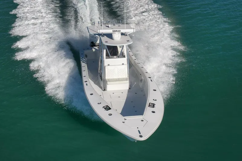 Slide: The Image of 2025 Conch 27 boat cruising on clear blue water, creating a dynamic wake. - 15