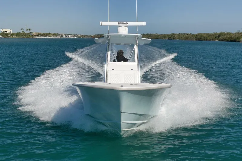 Slide: The Image of 2025 Conch 27 boat cruising on clear blue water, creating a dynamic wake. - 16