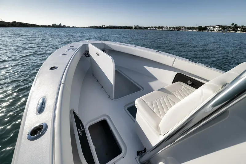 Slide: The Image of 2025 Conch 27 boat interior with seating and storage, on calm water. - 22
