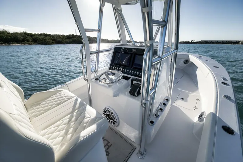 Slide: The Image of 2025 Conch 27 boat interior with modern helm, luxurious seating, and scenic water view. - 29