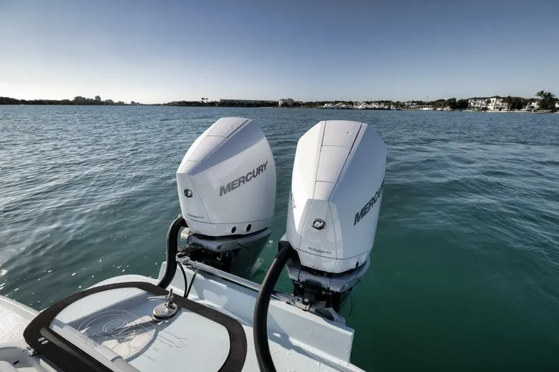 Slide: The Image of Twin Mercury outboard engines on a 2025 Conch 27 boat, cruising on calm waters. - 34