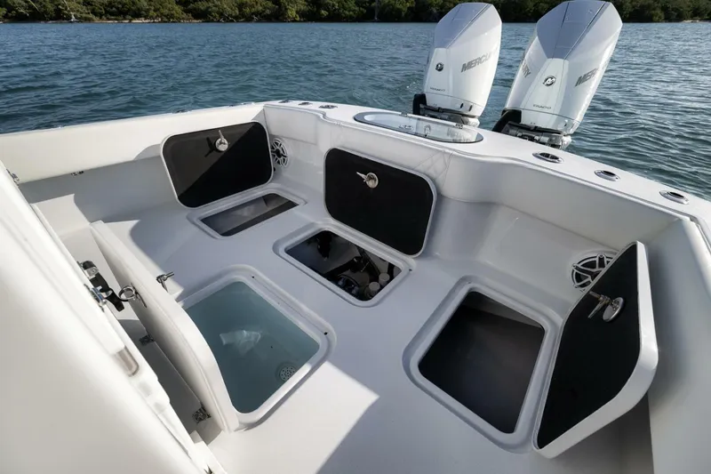 Slide: The Image of 2025 Conch 27 boat with open storage compartments and dual Mercury engines on water. - 35