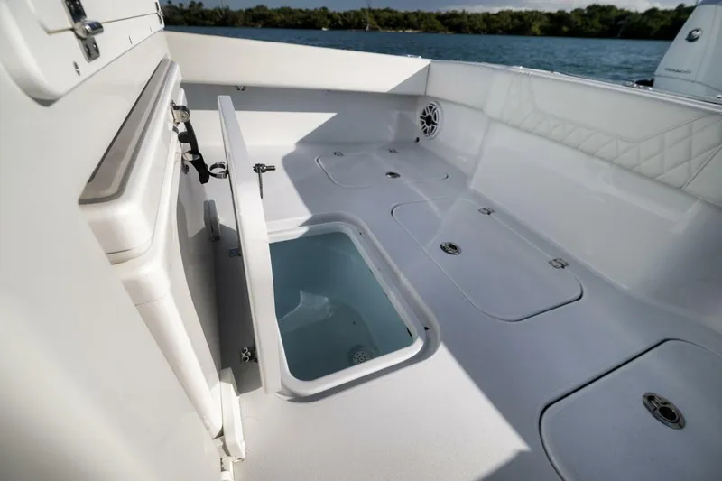 Slide: The Image of 2025 Conch 27 boat interior with open storage compartments and seating, near water. - 37