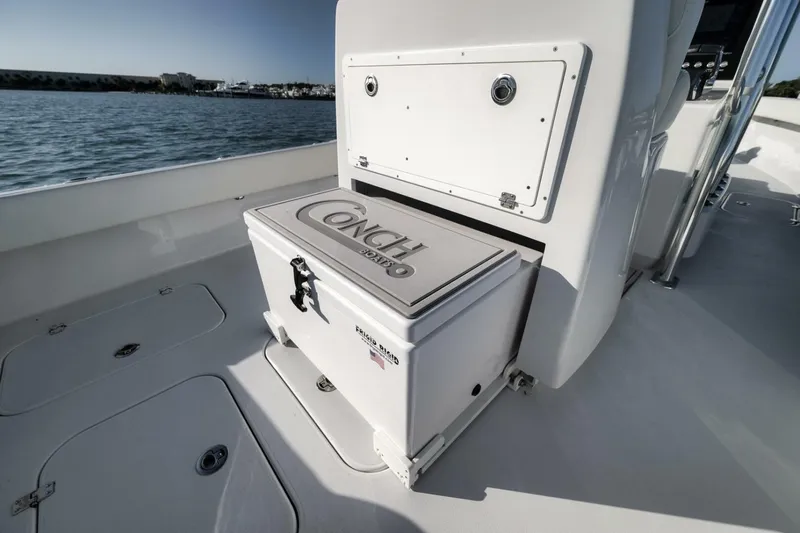 Slide: The Image of 2025 Conch 27 boat interior with storage compartment, ocean view in background. - 39