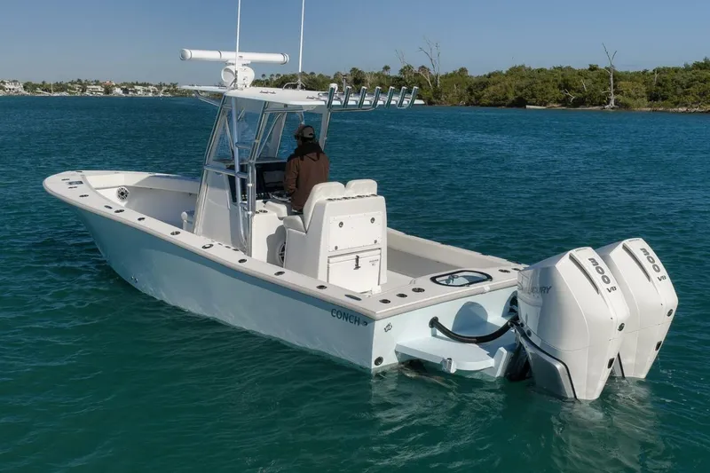 Slide: The Image of 2025 Conch 27 boat with dual Mercury engines on calm water. - 4