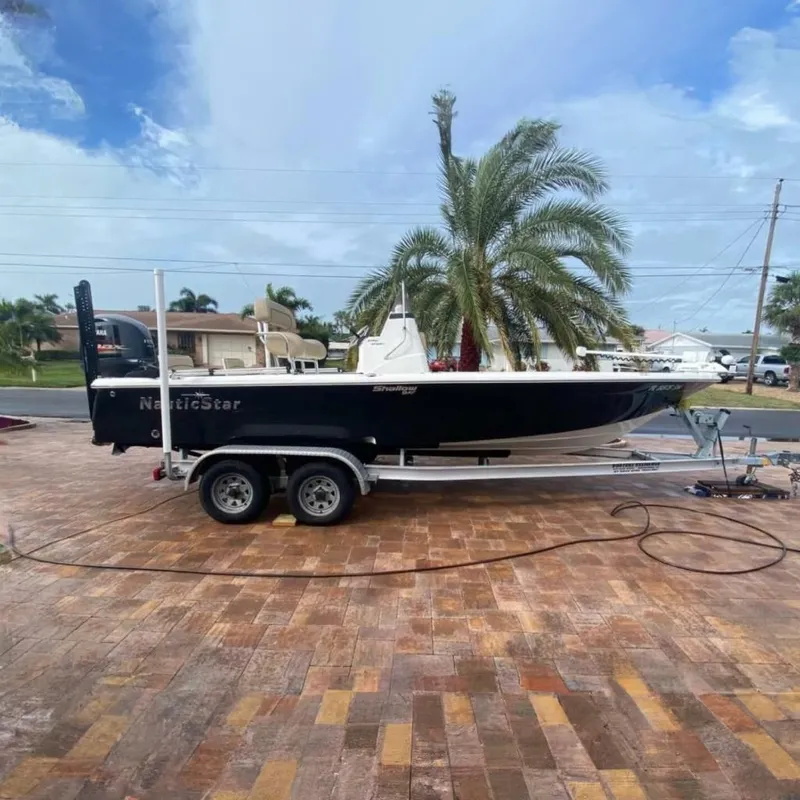 The Image of 2020 NauticStar 2140 Sport Shallow Bay boat on trailer, parked on brick driveway. - 0