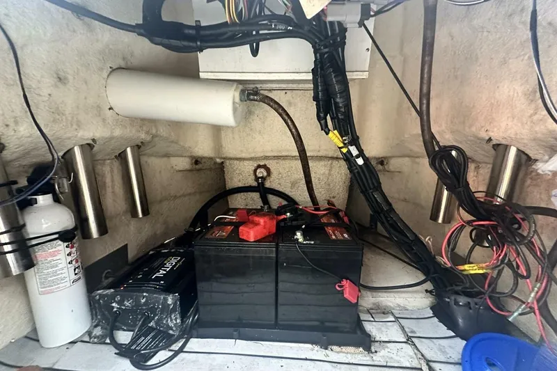 Slide: The Image of 2020 NauticStar 2140 Sport Shallow Bay boat battery compartment with wiring and fire extinguisher. - 22
