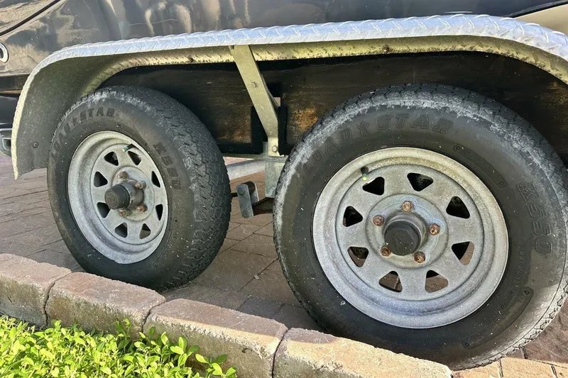 Slide: The Image of Trailer wheels of a 2020 NauticStar 2140 Sport Shallow Bay boat on pavement. - 46