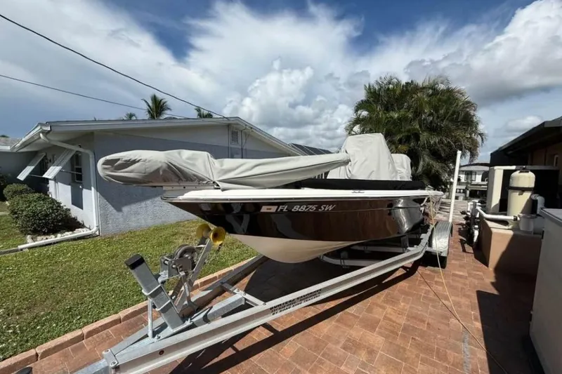 Slide: The Image of 2020 NauticStar 2140 Sport Shallow Bay boat on trailer, covered, in residential driveway. - 56