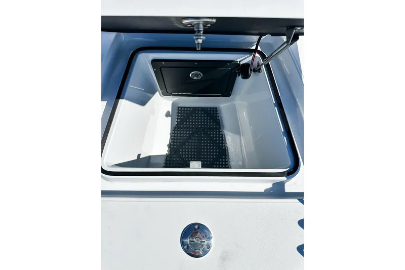 Slide: The Image of Open storage compartment of 2020 East Cape Evo V boat, featuring a black mat and secure latch. - 10