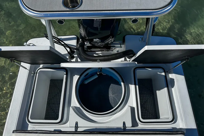 Slide: The Image of 2020 East Cape Evo V boat with open storage compartments and motor, viewed from above. - 14