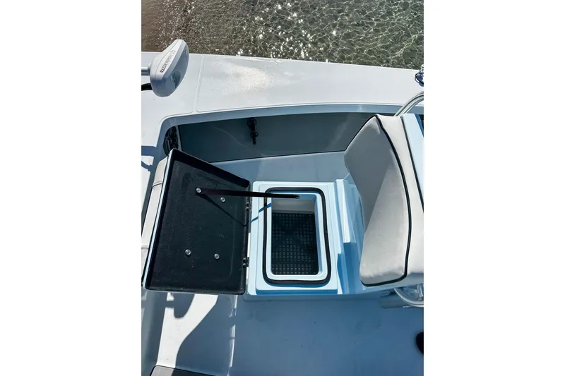 Slide: The Image of 2020 East Cape Evo V boat interior with open storage compartment and cushioned seat. - 18