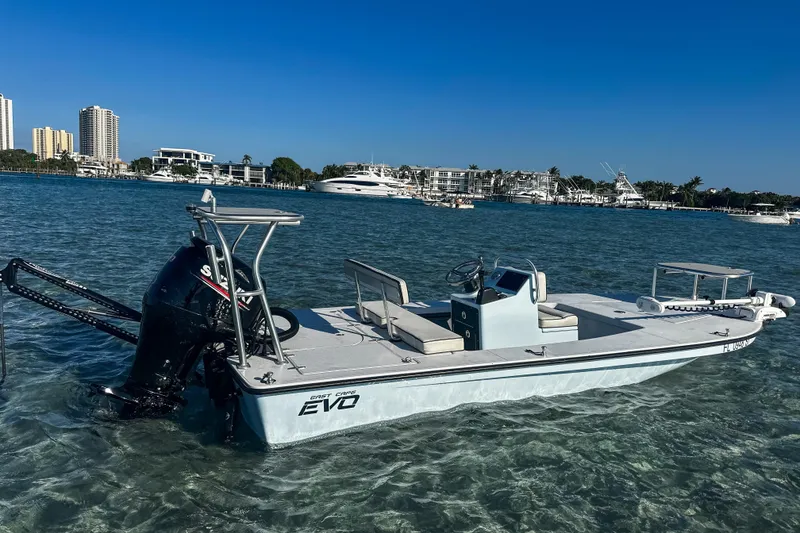 Slide: The Image of 2020 East Cape Evo V boat in clear water, city skyline in background. - 2