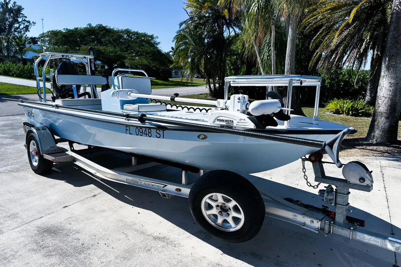Slide: The Image of 2020 East Cape Evo V boat on trailer, parked outdoors with palm trees in background. - 22
