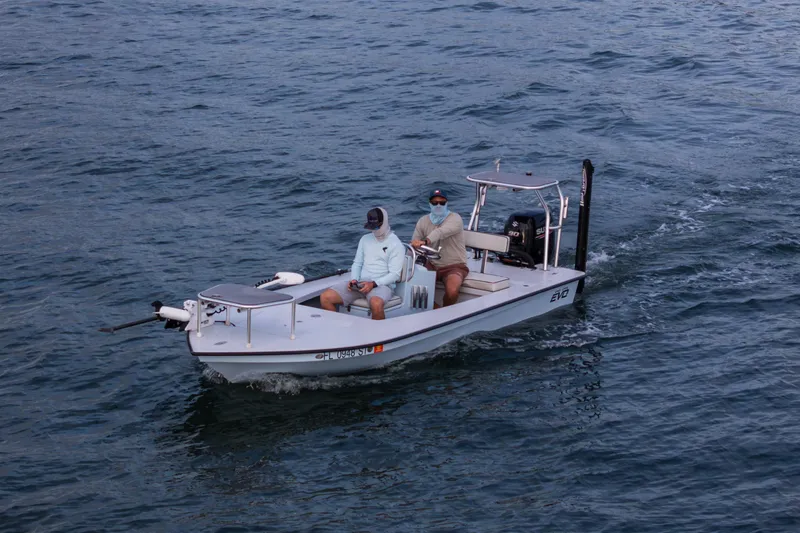 Slide: The Image of Two people on a 2020 East Cape 18 EVO boat navigating through water. - 24