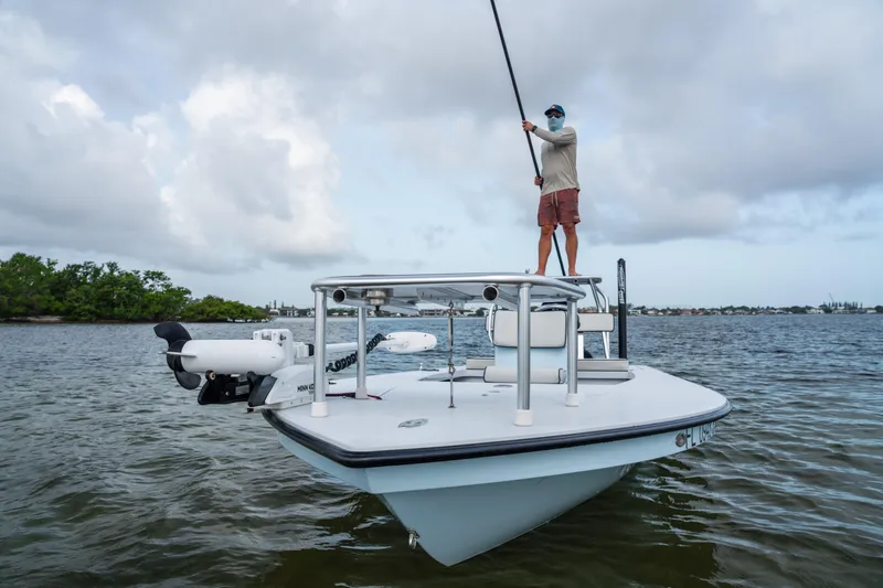 Slide: The Image of 2020 East Cape 18 EVO boat with person poling in calm waters under cloudy sky. - 34