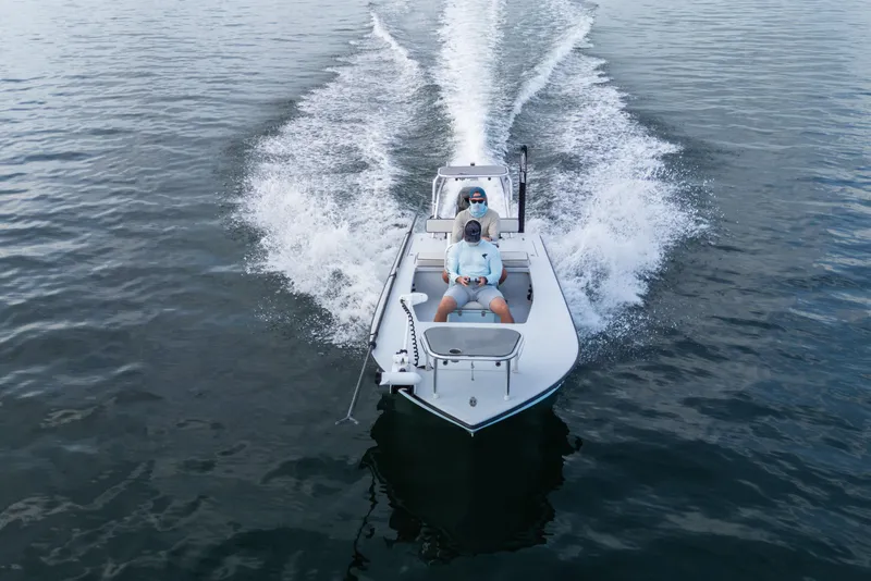 Slide: The Image of 2020 East Cape 18 EVO boat cruising on open water with two passengers. - 27