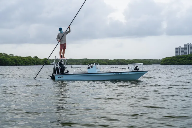 Slide: The Image of Man poling on a 2020 East Cape 18 EVO boat in calm waters. - 33