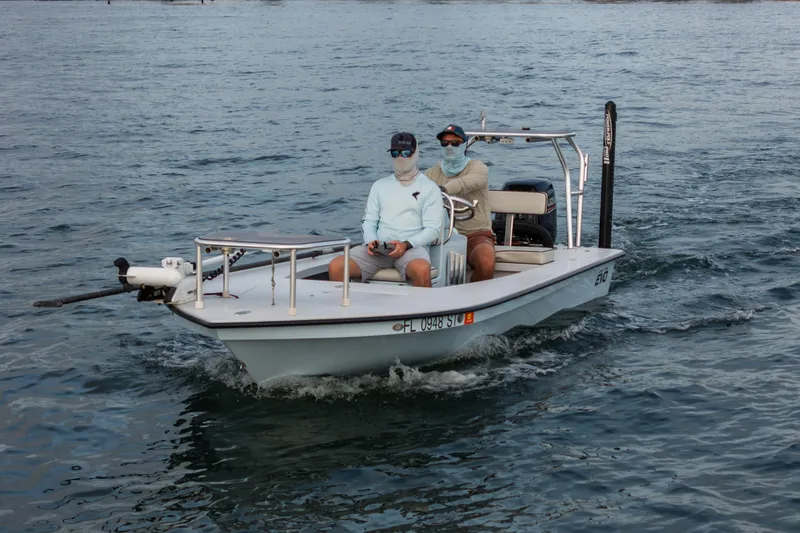 Slide: The Image of 2020 East Cape 18 EVO boat with two people cruising on the water. - 26