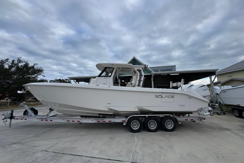The Image of 2026 Solace 35 CS boat on trailer, parked outdoors under cloudy sky. - 1