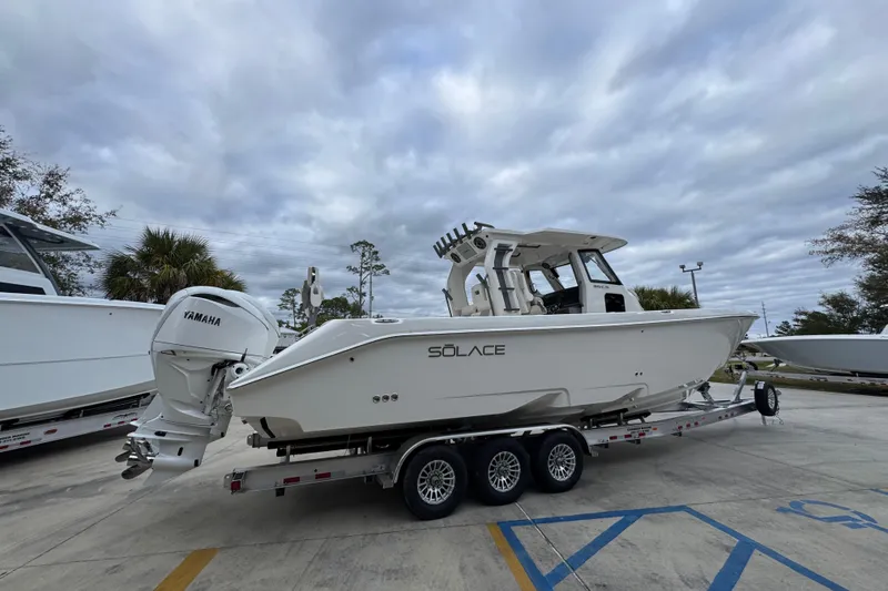 Slide: The Image of 2026 Solace 35 CS boat on trailer, featuring Yamaha outboard motor, under cloudy sky. - 12