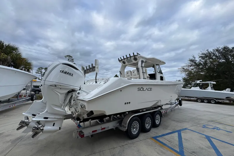 Slide: The Image of 2026 Solace 35 CS boat with Yamaha engines on a trailer, under cloudy skies. - 13