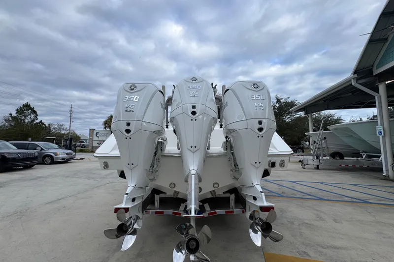Slide: The Image of 2026 Solace 35 CS boat with triple 350 V6 outboard engines, parked outdoors. - 15