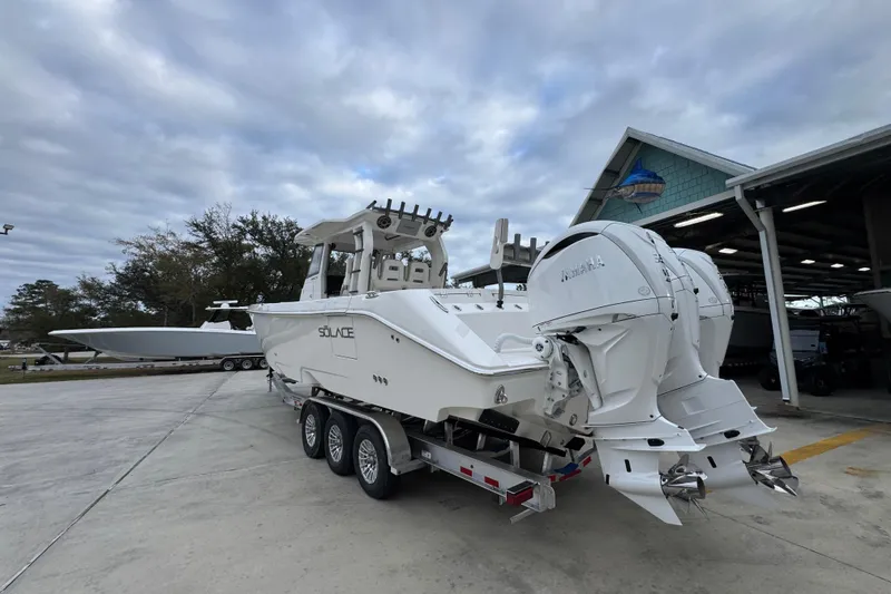 Slide: The Image of 2026 Solace 35 CS boat on trailer with dual Yamaha outboard engines, parked outdoors. - 17