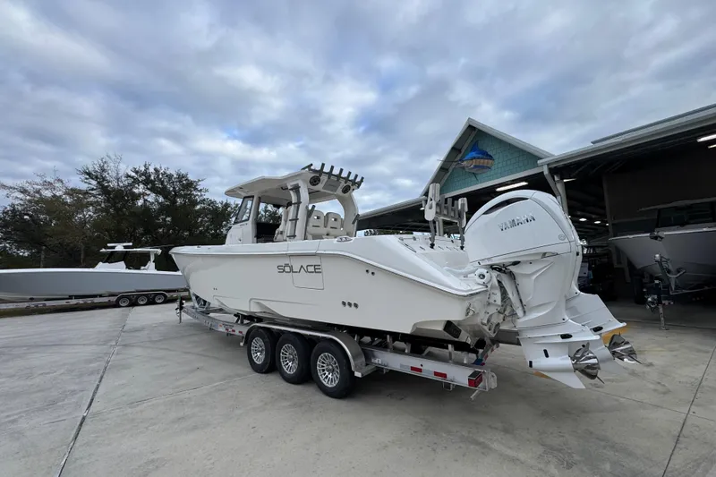 Slide: The Image of 2026 Solace 35 CS boat on trailer, featuring dual Yamaha engines, parked outdoors. - 18