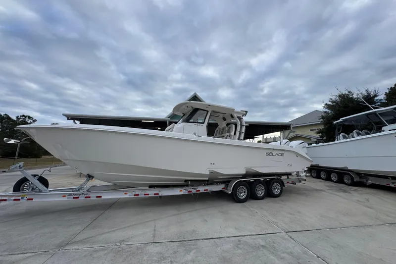 Slide: The Image of 2026 Solace 35 CS boat on trailer under cloudy sky. - 2