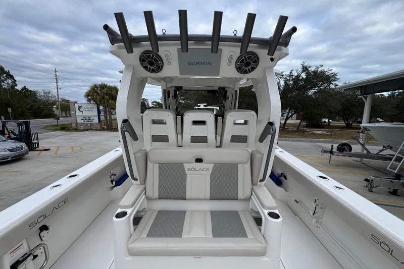 Slide: The Image of 2026 Solace 35 CS boat interior with seating and rod holders, parked outdoors. - 45