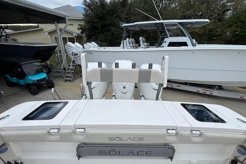 Slide: The Image of 2026 Solace 35 CS boat with triple outboard engines in a marina setting. - 49