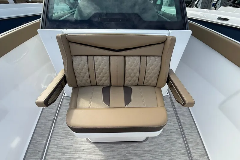 Slide: The Image of Luxury seating on 2026 Monterey Elite 27 OB boat, featuring tan upholstery and armrests. - 23
