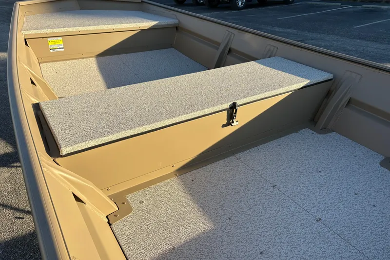 Slide: The Image of 2026 SeaArk 1648 MV boat interior with carpeted seating and storage compartments. - 11