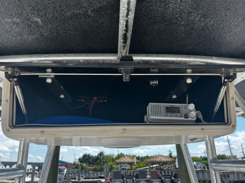 Slide: The Image of 2015 Carolina Skiff 21 Ultra Elite boat console with radio equipment and storage compartment. - 8