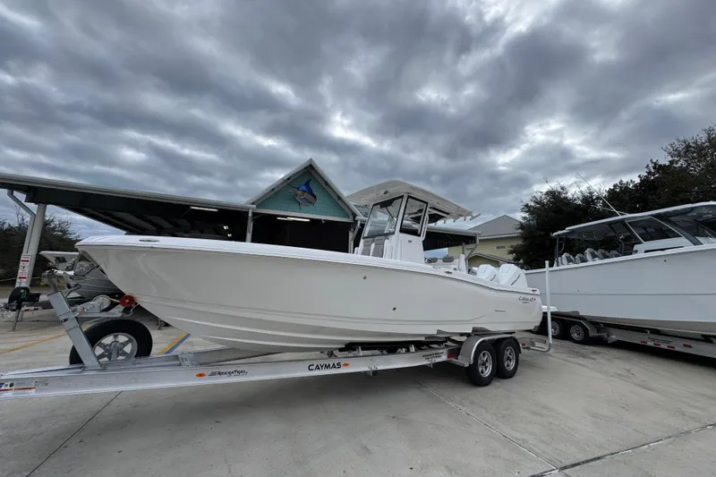 Slide: The Image of 2026 Caymas 291 boat on trailer under cloudy sky. - 13