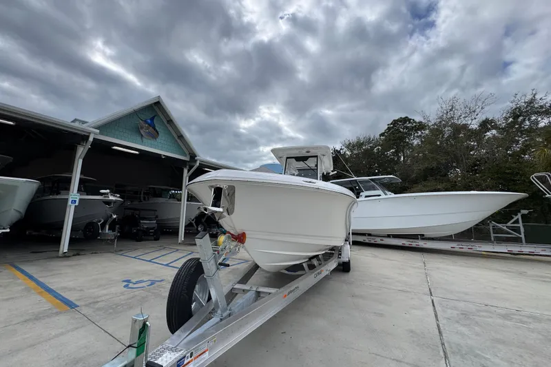 Slide: The Image of 2026 Caymas 291 boat on trailer under cloudy sky at dealership. - 15