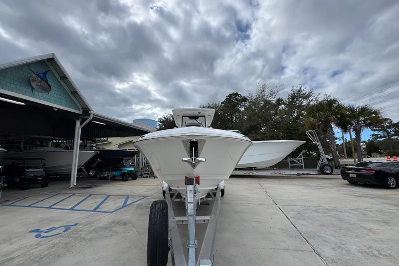 Slide: The Image of 2026 Caymas 291 boat on trailer under cloudy sky at dealership. - 16