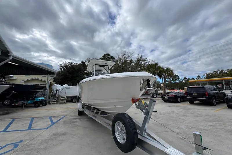 Slide: The Image of 2026 Caymas 291 boat on trailer under cloudy sky at dealership. - 17